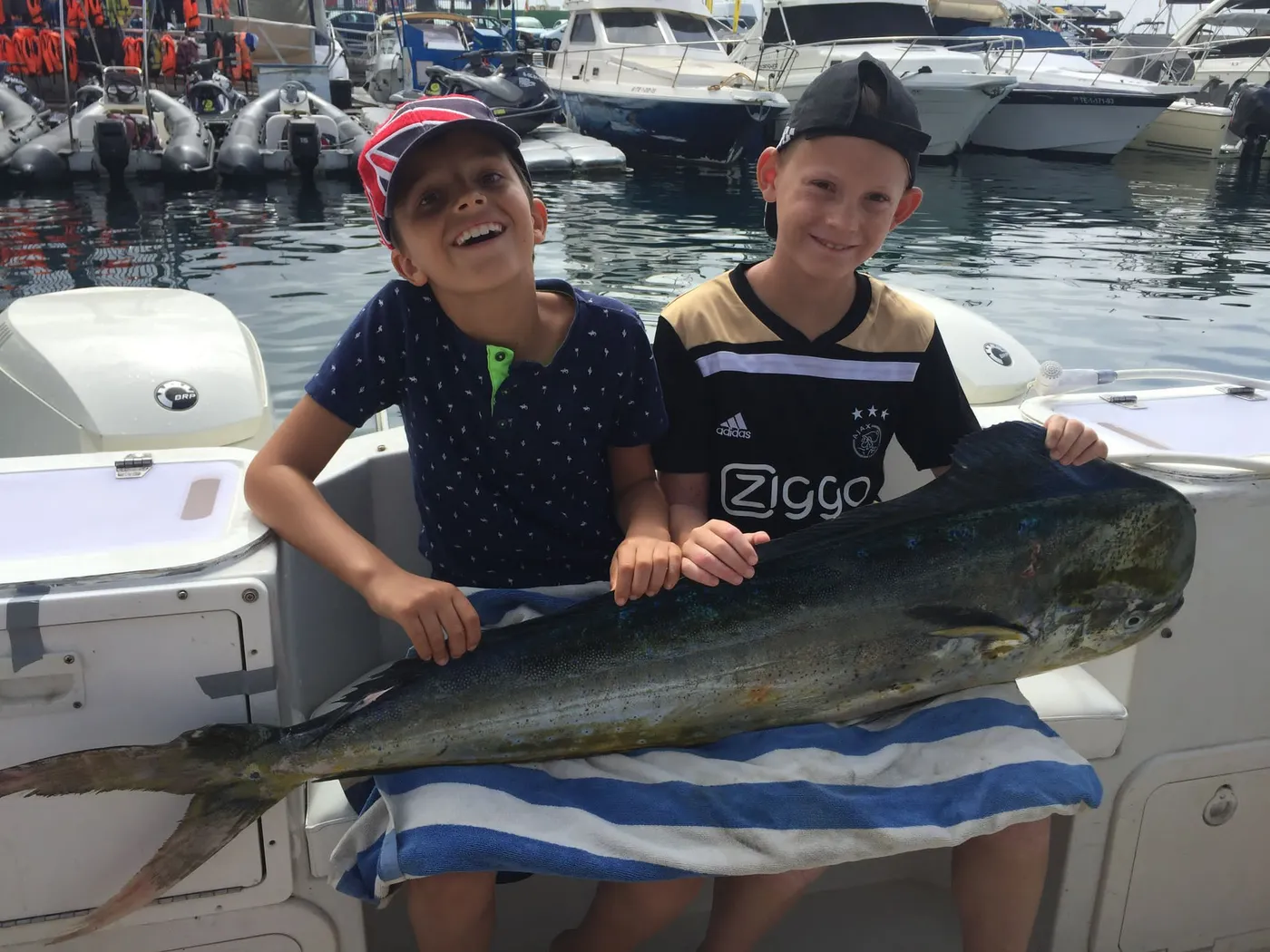 Dorado — one of the species Barco 33 works the near shelf for. Photo from our fleet at Puerto Colón. Two young anglers holding a dorado landed with the Tenerife Fishing Experts fleet at Puerto Colón